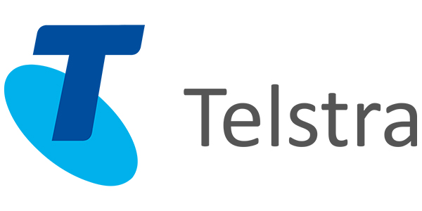Telstra logo featuring a stylized blue letter "T" and the word "Telstra" in gray, representing a trusted brand in communication services for The Visual Storytellers Group.